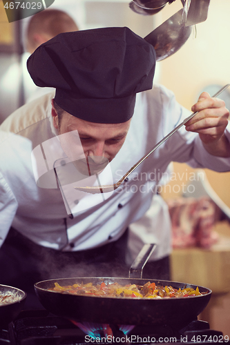 Image of chef tasting food with spoon