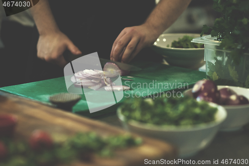 Image of Chef  hands cutting the onion with knife