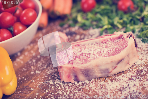Image of Juicy slice of raw steak on wooden table