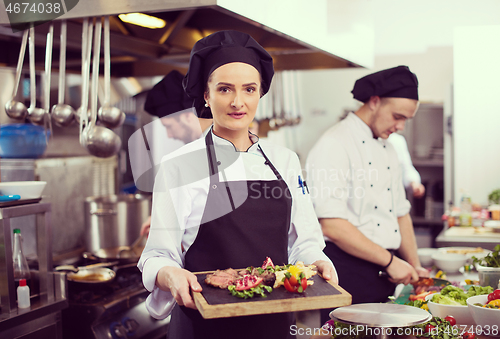 Image of female Chef holding beef steak plate