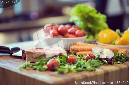 Image of Juicy slice of raw steak on wooden table