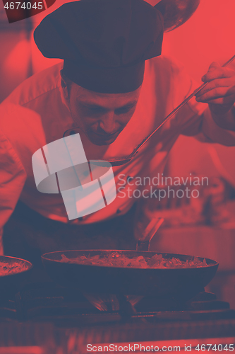 Image of chef tasting food with spoon
