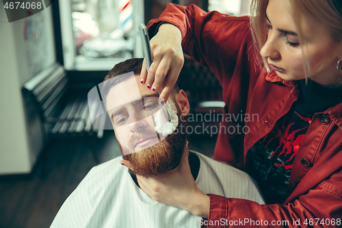 Image of Client during beard shaving in barber shop