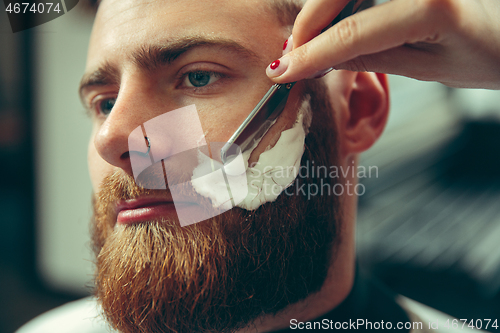 Image of Client during beard shaving in barber shop