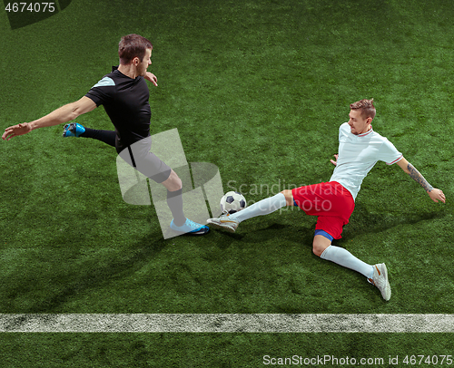 Image of Football players tackling ball over green grass background