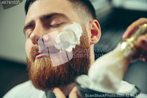 Image of Client during beard shaving in barber shop