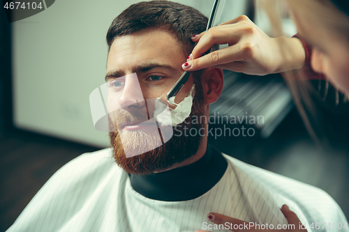 Image of Client during beard shaving in barber shop