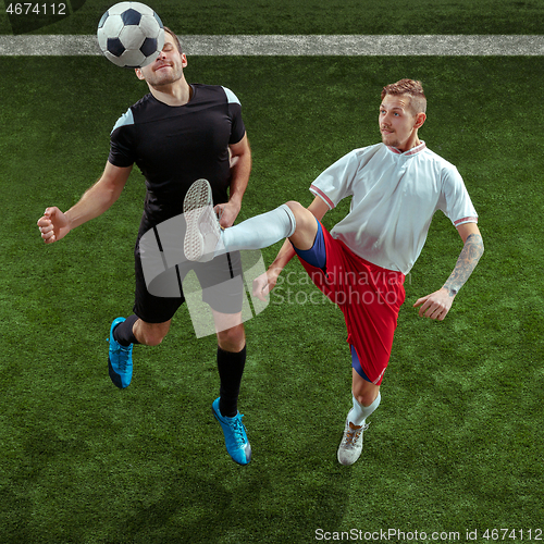 Image of Football players tackling ball over green grass background