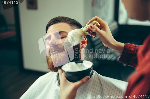 Image of Client during beard shaving in barber shop