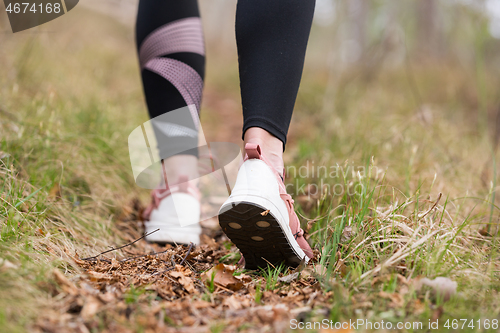 Image of Rear close up view of female step on nature track. Young woman hiking in nature. Adventure, sport and exercise concept