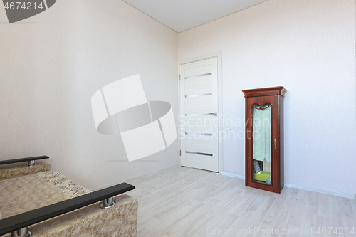 Image of The interior of a modest small bedroom with very poor furniture