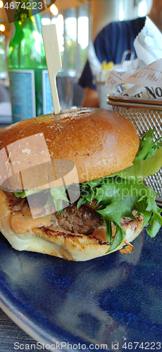 Image of Gourmet burger plated meal on the table in restaurant