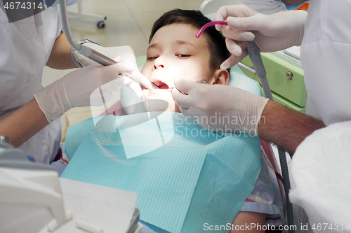 Image of Dentist examining boy mouth