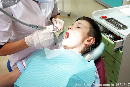 Image of Dentist examining boy mouth