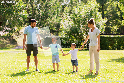 Image of happy family holding hands at summer park