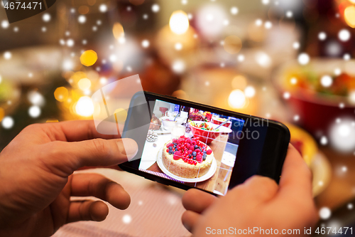 Image of hands photographing food at christmas dinner