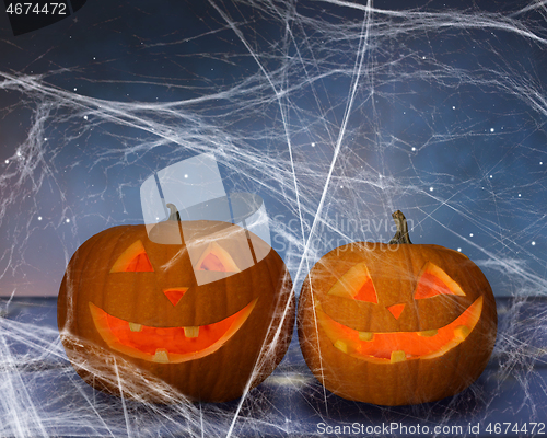Image of two pumpkins or jack o lanterns and spiderweb