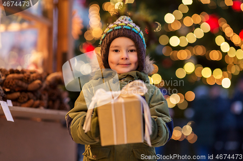 Image of happy boy with gift box at christmas market