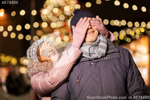 Image of happy senior couple at christmas market