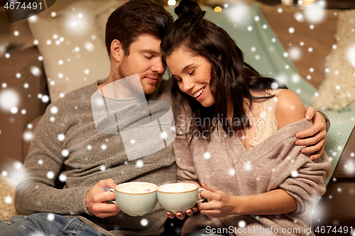 Image of happy couple drinking hot chocolate on christmas