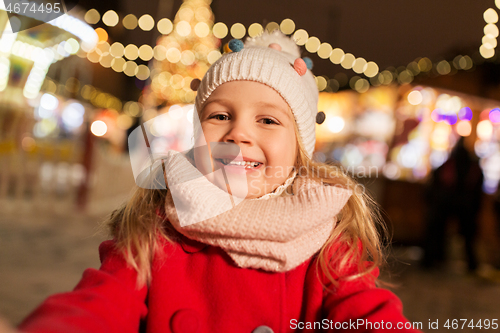 Image of little girl taking selfie at christmas market