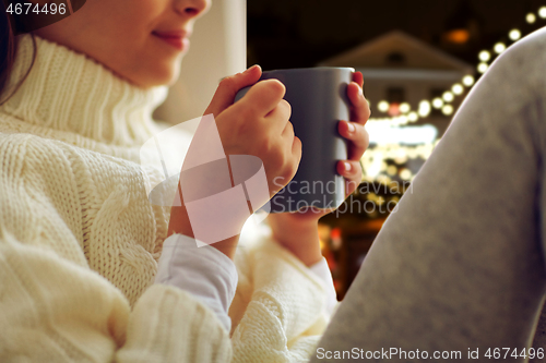 Image of close up of girl with tea mug sitting at window