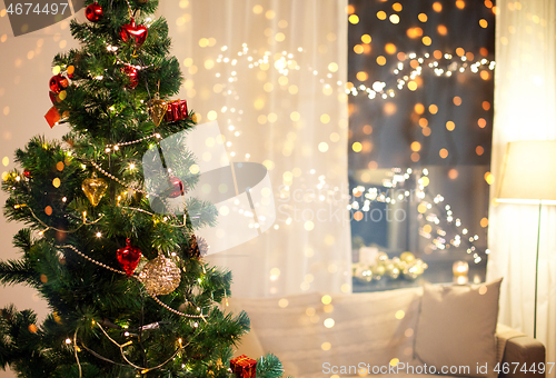 Image of close up of christmas tree at home in evening