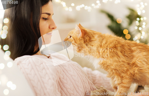 Image of close up of owner with red cat in bed at home