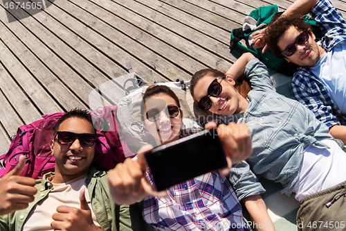 Image of friends or tourists with backpacks taking selfie