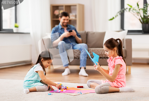 Image of happy sisters doing arts and crafts at home