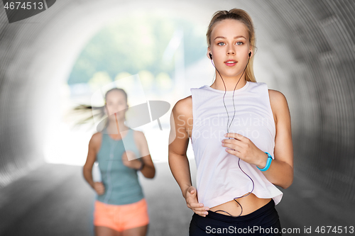 Image of women or female friends with earphones running