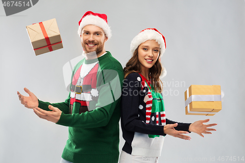 Image of happy couple in christmas sweaters with gifts