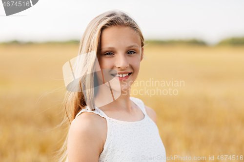 Image of smiling young girl on cereal field in summer