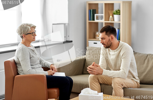 Image of senior woman psychologist and young man patient