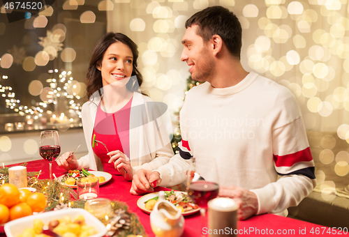 Image of happy couple eating at christmas dinner