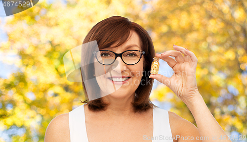 Image of senior woman with gold facial mask in bottle
