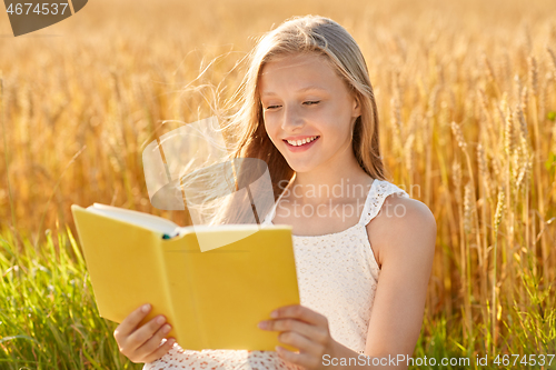 Image of smiling young girl reading book on cereal field