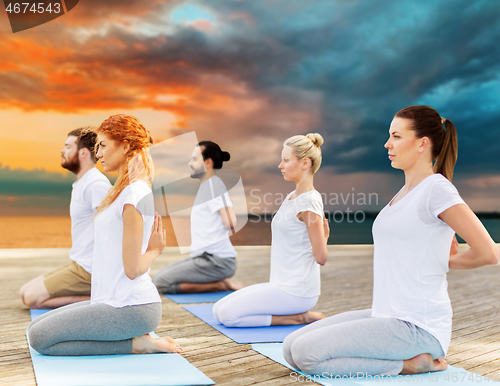 Image of people making yoga in hero pose outdoors