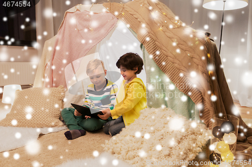 Image of little boys with tablet pc in kids tent at home