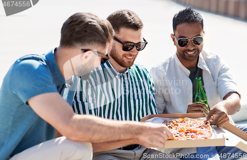 Image of male friends eating pizza with beer on street