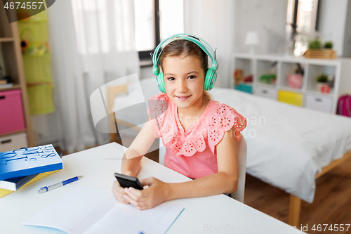 Image of girl in headphones listening to music on cellphone