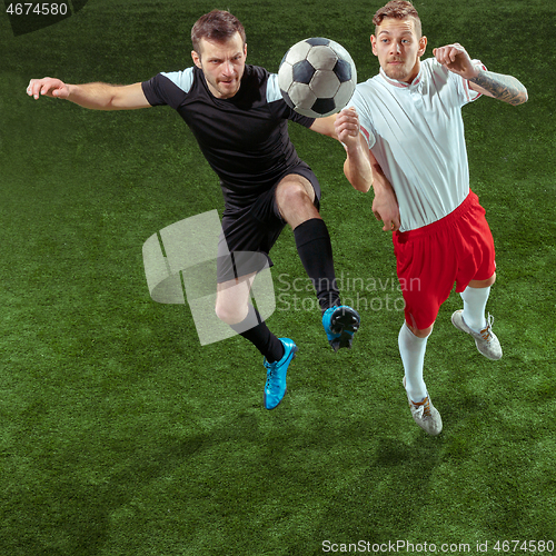 Image of Football players tackling ball over green grass background