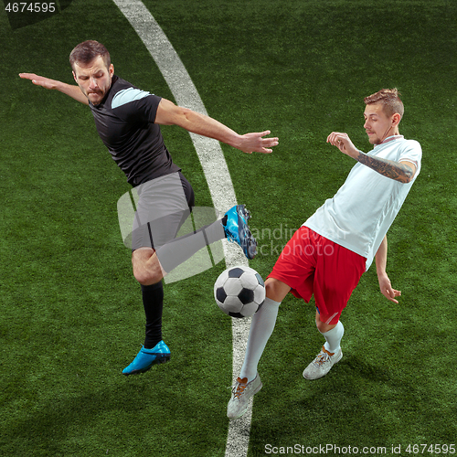 Image of Football players tackling ball over green grass background