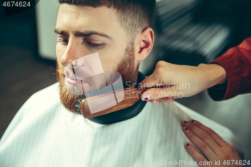 Image of Client during beard shaving in barber shop