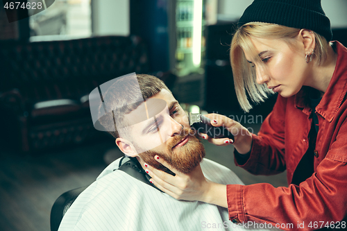 Image of Client during beard shaving in barber shop