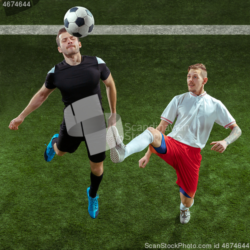 Image of Football players tackling ball over green grass background