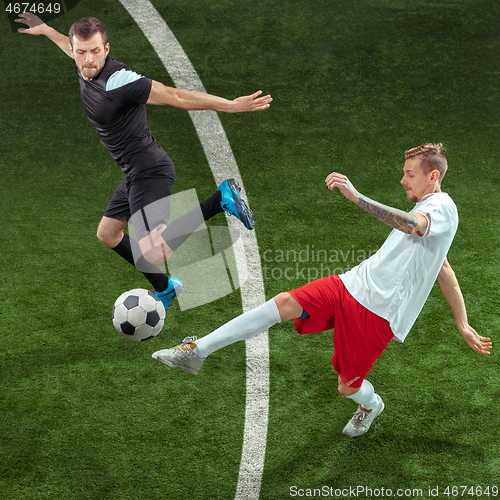 Image of Football players tackling ball over green grass background