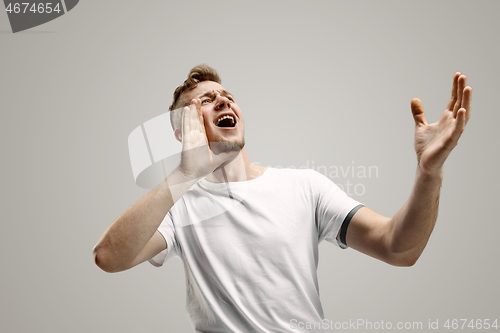 Image of Isolated on gray young casual man shouting at studio