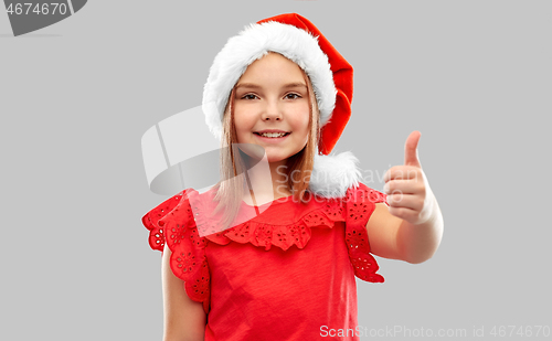 Image of smiling girl in snata helper hat showing thumbs up