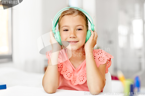 Image of girl in headphones listening to music at home